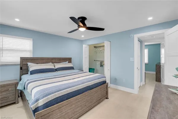 a bedroom with a large bed and a chandelier