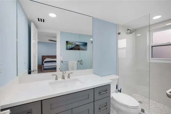 a bathroom with a sink a toilet a shower and a mirror