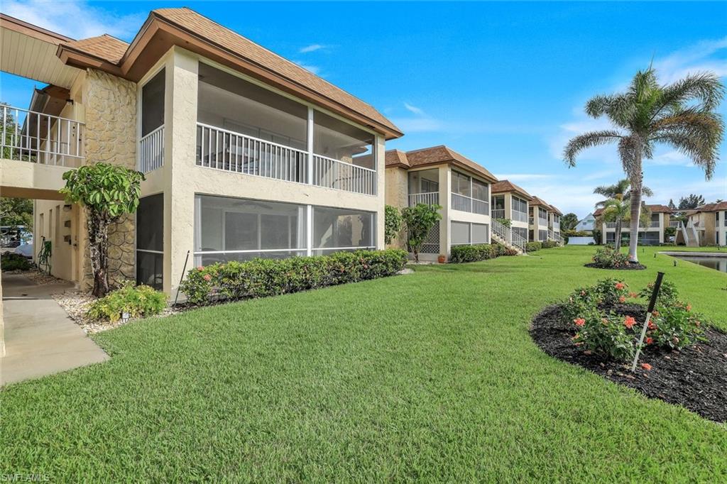 1155 Sandpiper Street, Unit C7 Naples, FL 34102 - Photo 17 of 23 a front view of a house with a yard