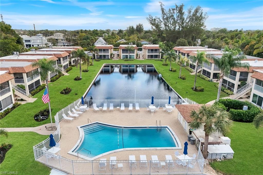 1155 Sandpiper Street, Unit C7 Naples, FL 34102 - Photo 19 of 23 a view of a swimming pool with a yard