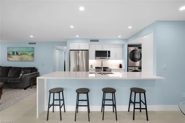 a large kitchen with kitchen island granite countertop a table and chairs