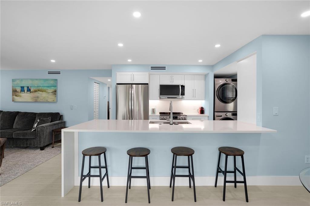 1155 Sandpiper Street, Unit C7 Naples, FL 34102 - Photo 6 of 23 a large kitchen with kitchen island granite countertop a table and chairs