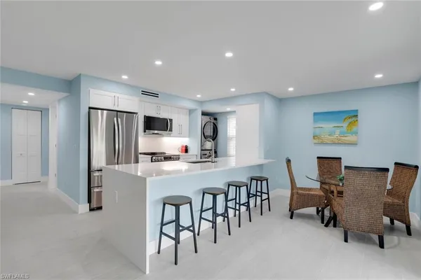 a large kitchen with a table and chairs