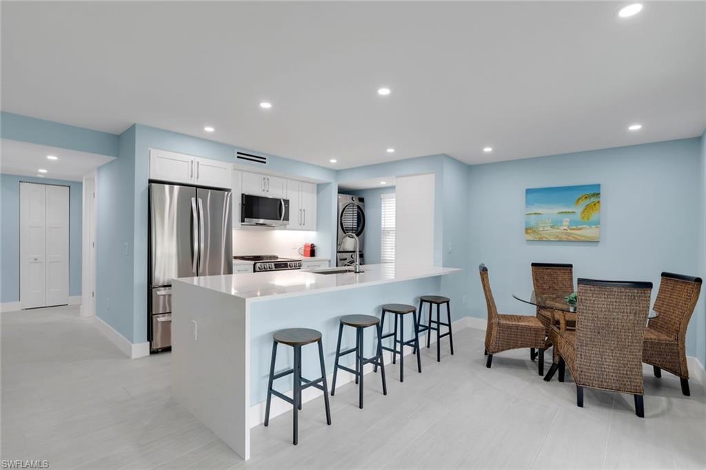 1155 Sandpiper Street, Unit C7 Naples, FL 34102 - Photo 8 of 23 a large kitchen with a table and chairs