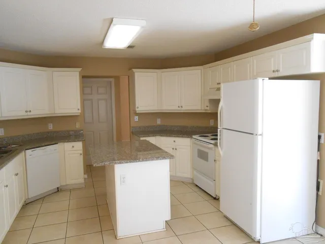 a kitchen with a refrigerator sink and cabinets