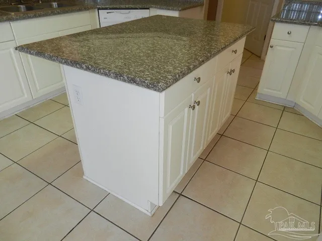 a kitchen with granite countertop sink and cabinets