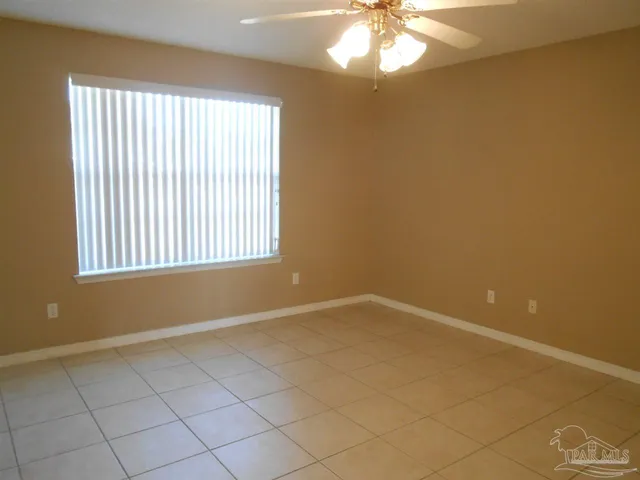 en empty room with windows and chandelier fan