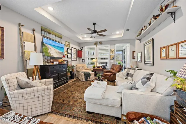 a living room with furniture kitchen view and a large window