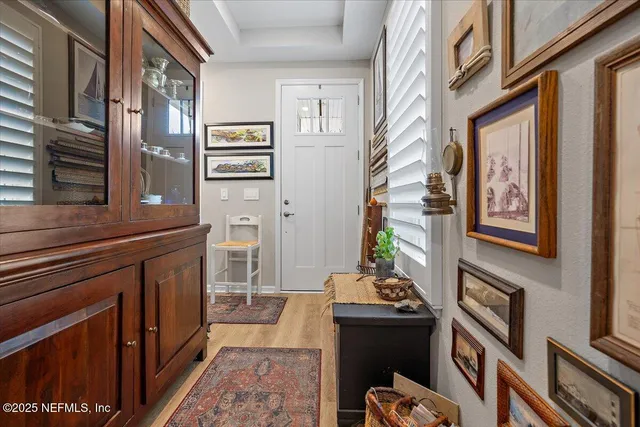 a living room with furniture a flat screen tv and a refrigerator