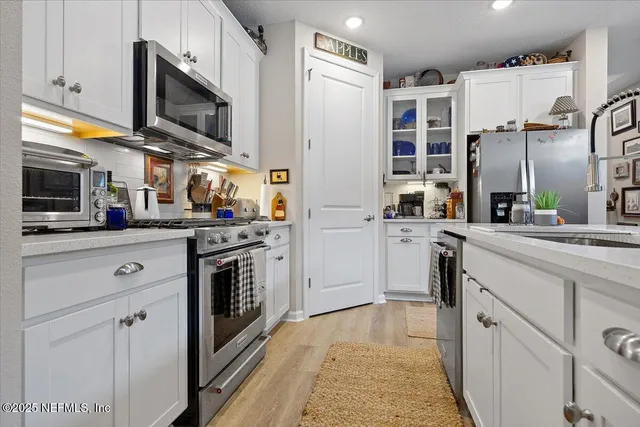 a kitchen with stainless steel appliances a stove microwave and cabinets