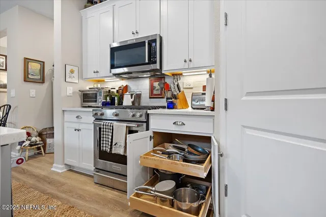 a kitchen with stainless steel appliances a stove a microwave and cabinets