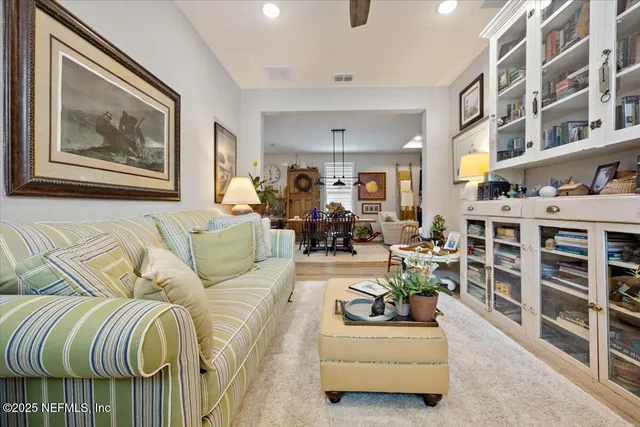 a living room with furniture and a book shelf