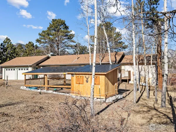 a view of house with large trees and wooden fence