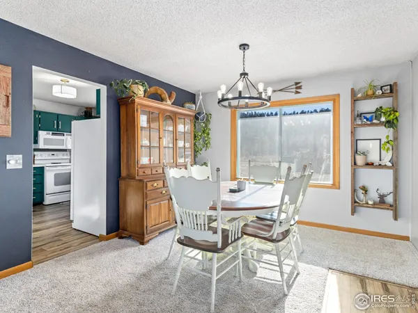 a dining room with furniture a chandelier and wooden floor