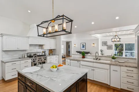 a kitchen with stainless steel appliances granite countertop a sink stove and cabinets