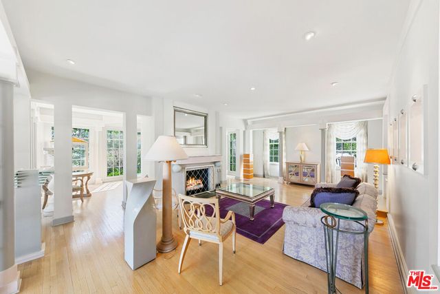 a living room with furniture a large window and wooden floor
