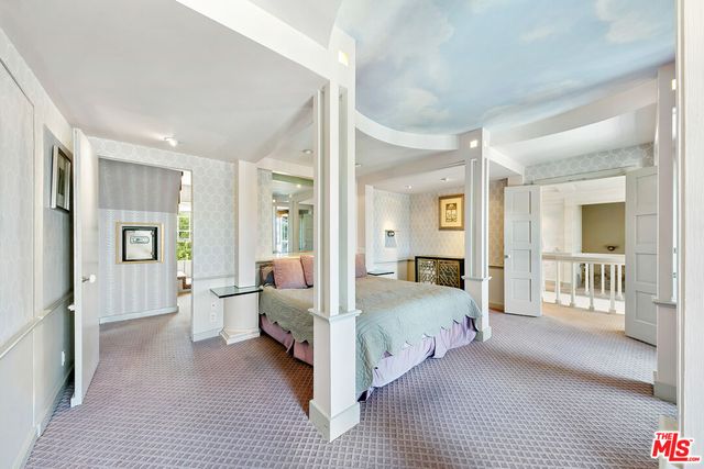 a bedroom with a large bed and a chandelier