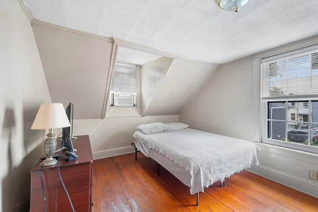 a bedroom with a bed and wooden floor