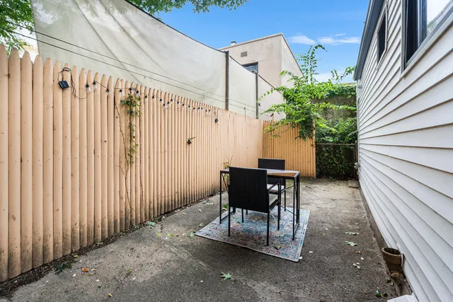 a view of backyard with a table and chairs and potted plants