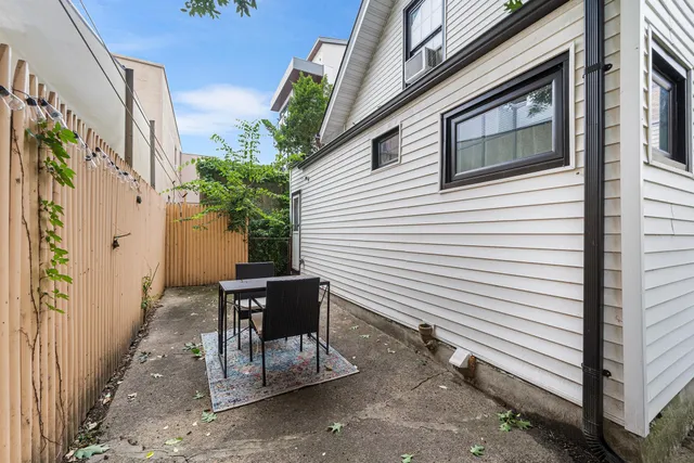 a view of a patio with a table and chairs and potted plants