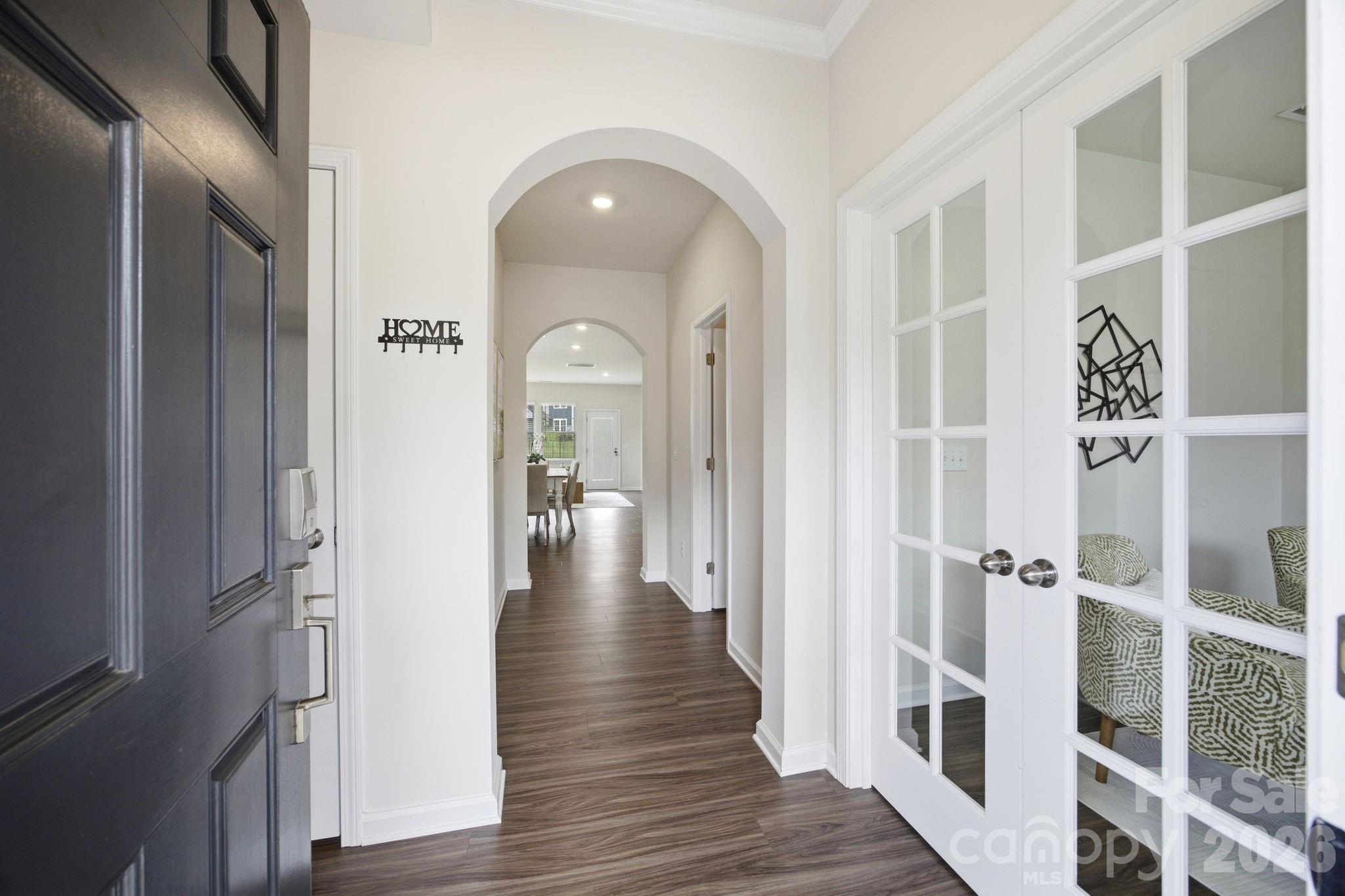234 Hamptons Cove Road Troutman, NC 28166 - Photo 3 of 32 a view of a hallway with wooden floor and staircase
