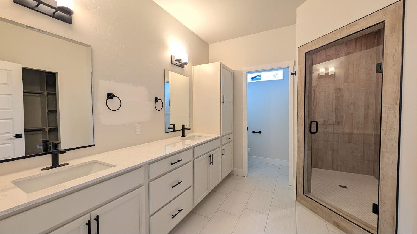 1730 Caliper Way Fruita, CO 81521 - Photo 12 of 15 a spacious bathroom with a shower sink and mirror