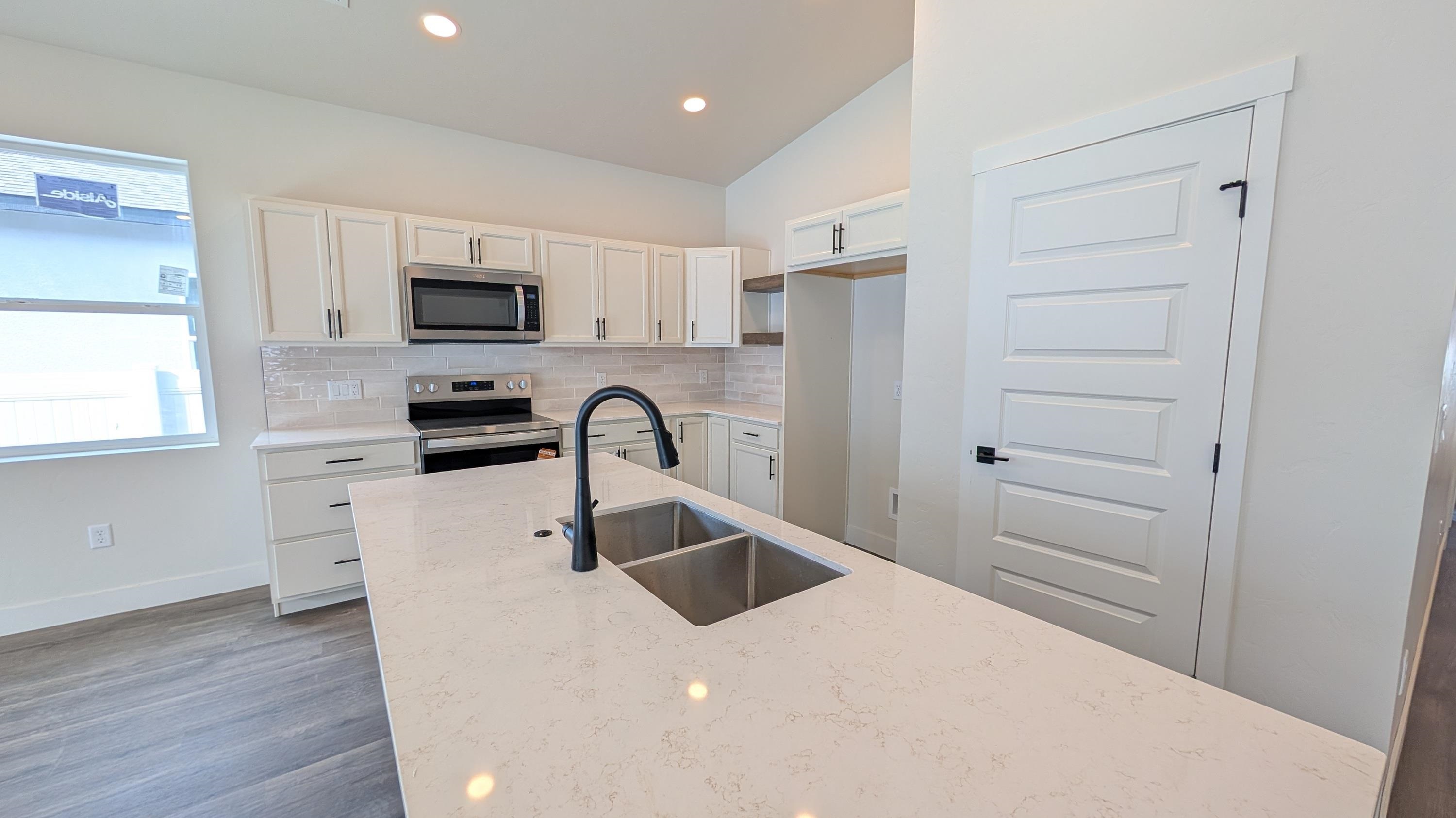 1730 Caliper Way Fruita, CO 81521 - Photo 5 of 15 a kitchen with stainless steel appliances a refrigerator sink and white cabinets