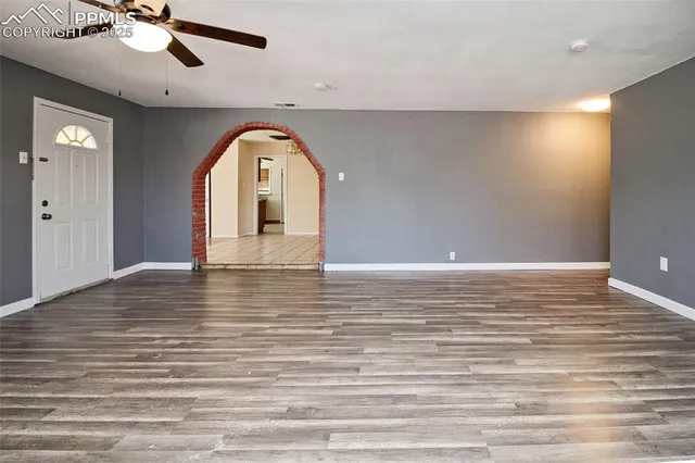 a view of empty room with wooden floor