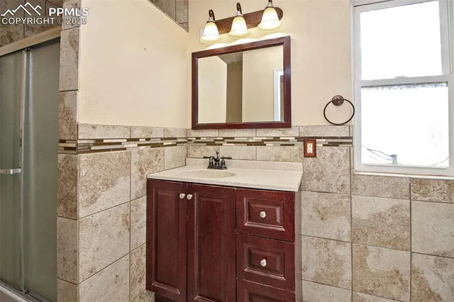 a bathroom with a sink vanity granite and a mirror