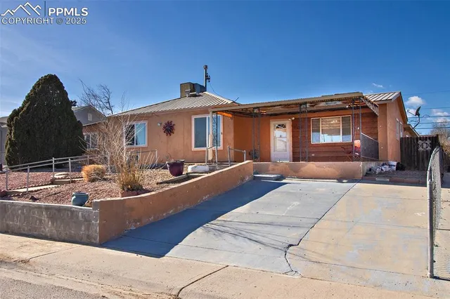 an empty room with a chandelier fan and windows