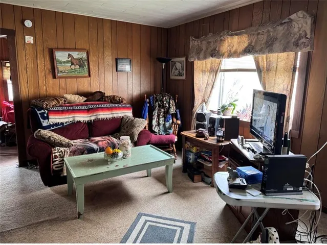 a living room with furniture a window and a flat screen tv