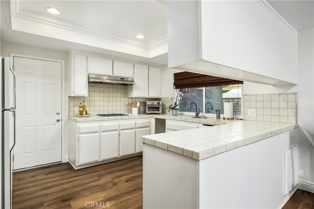 2126 Baseline Road La Verne, CA 91750 - Photo 13 of 39 a kitchen with a sink dishwasher a stove and white cabinets with wooden floor