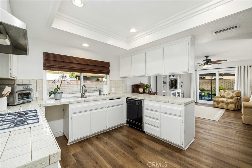 2126 Baseline Road La Verne, CA 91750 - Photo 14 of 39 a kitchen with stainless steel appliances granite countertop a stove top oven a sink dishwasher and white cabinets with wooden floor