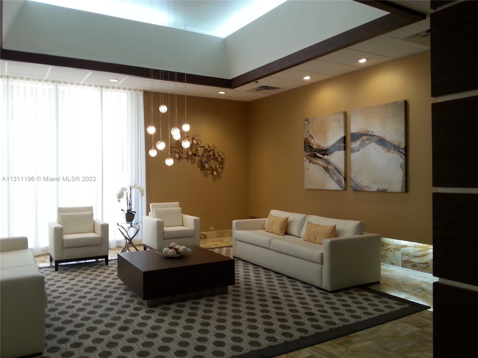 9511 Collins Avenue, Unit 1202 Surfside, FL 33154 - Photo 1 of 4 a living room with furniture and a large window