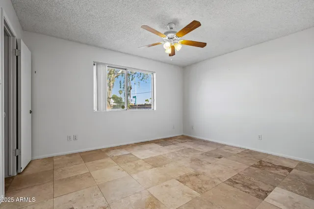 an empty room with fan and windows