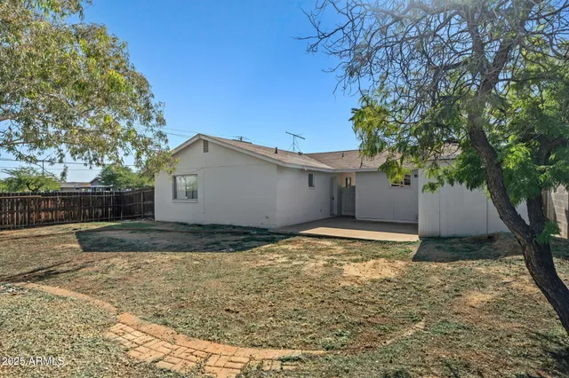 a view of a house with a yard and wooden fence