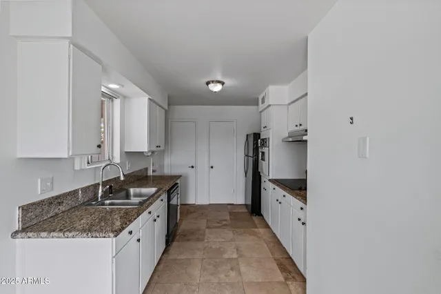 a kitchen with granite countertop a sink and cabinets