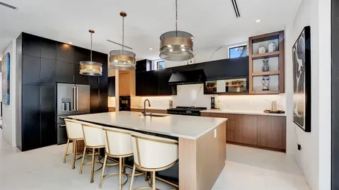 a bedroom with a bed a couch and a large window with wooden floor