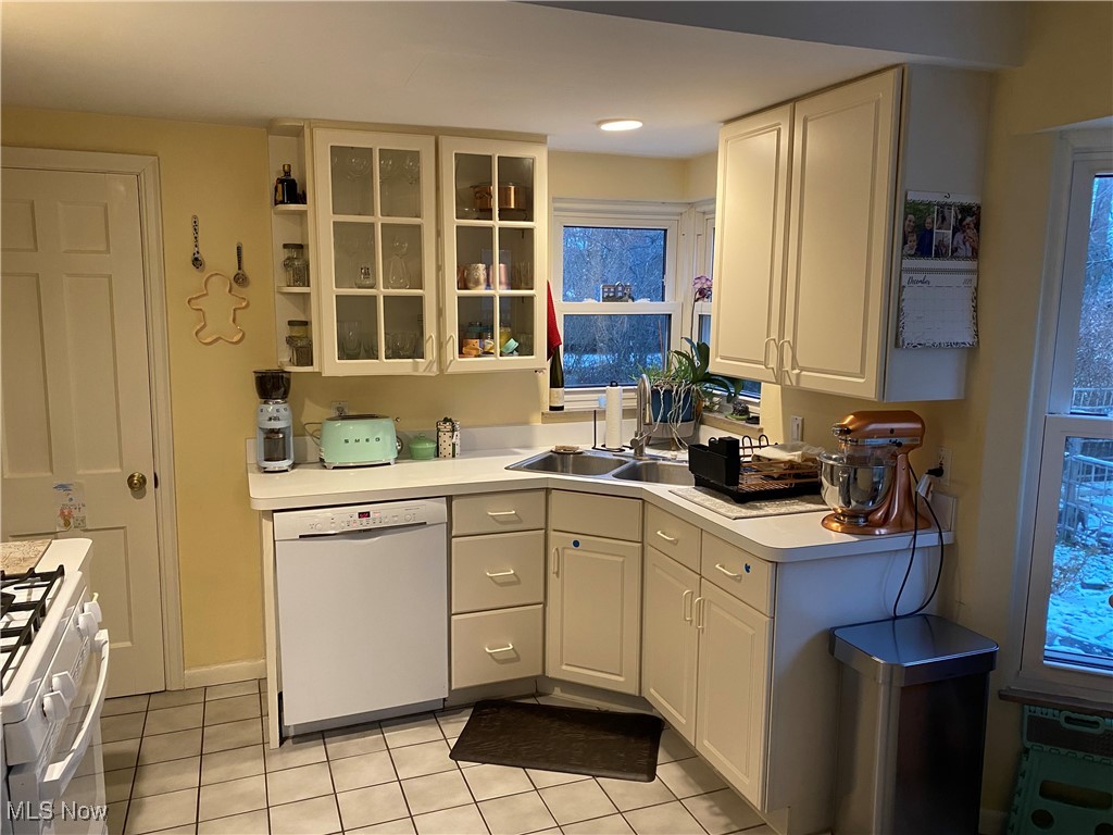 4663 Anderson Road Cleveland, OH 44121 - Photo 7 of 28 Kitchen featuring light tile patterned floors, white appliances, white cabinetry, and sink