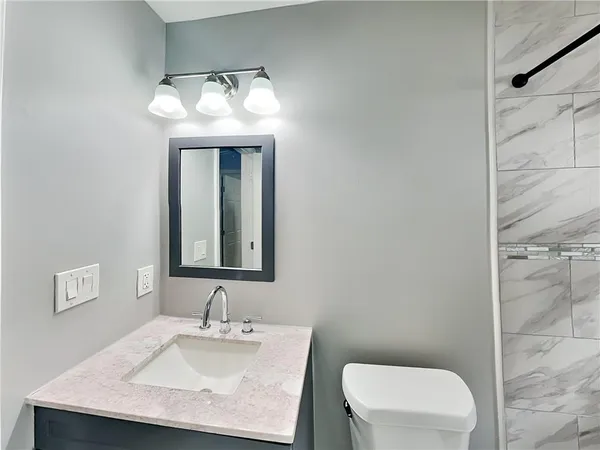 a bathroom with a sink vanity and toilet