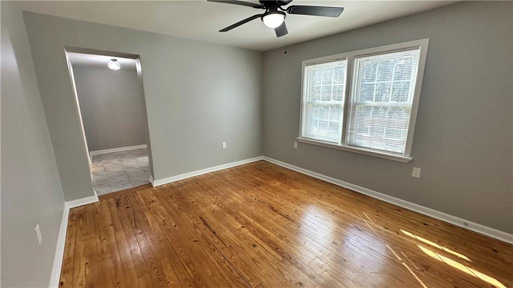 1770 Springview Road Northwest Atlanta, GA 30314 - Photo 15 of 30 a view of an empty room with a window and wooden floor