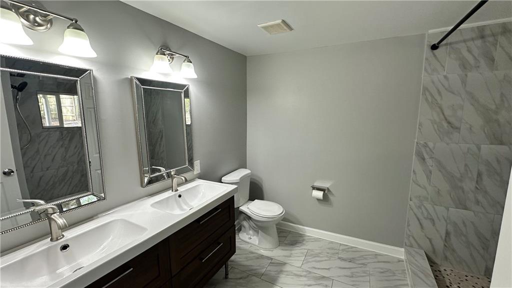 1770 Springview Road Northwest Atlanta, GA 30314 - Photo 18 of 30 a bathroom with a double vanity sink toilet and mirror