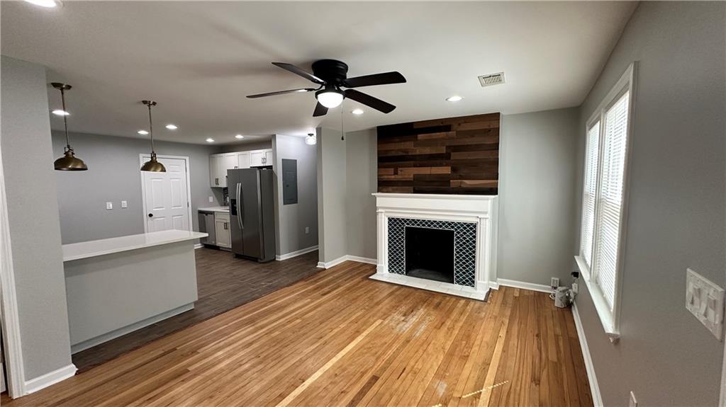 1770 Springview Road Northwest Atlanta, GA 30314 - Photo 6 of 30 a view of a livingroom with a fireplace a ceiling fan and wooden floor