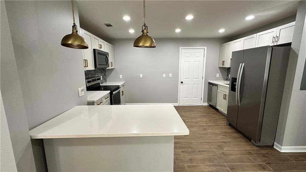 1770 Springview Road Northwest Atlanta, GA 30314 - Photo 9 of 30 a kitchen with stainless steel appliances a refrigerator and a table