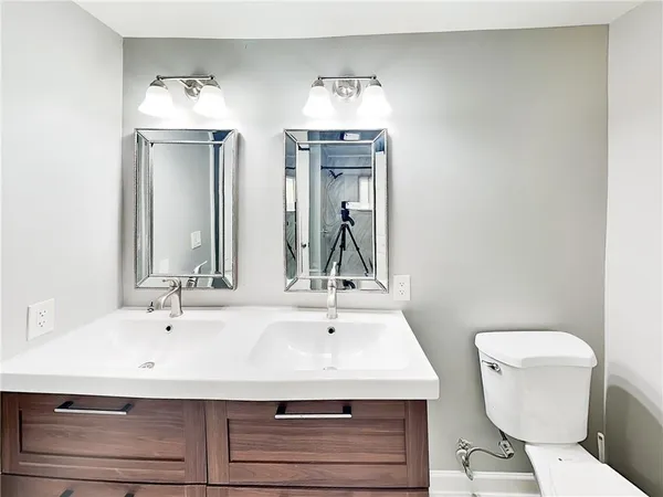 a bathroom with a sink a toilet and mirror