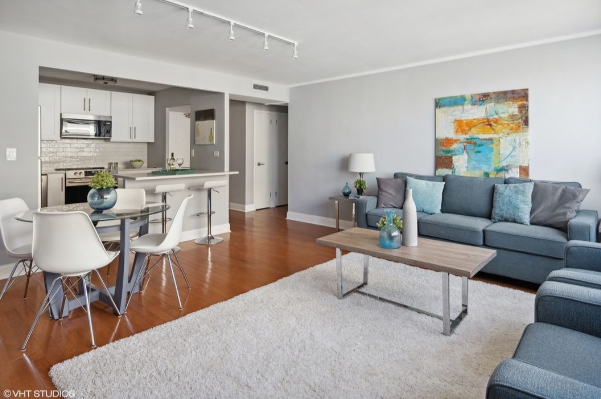 6301 North Sheridan Road, Unit 19D Chicago, IL 60660 - Photo 5 of 11 a living room with furniture a fireplace a rug and kitchen view