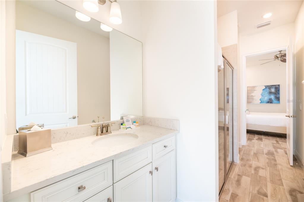 8145 Surf Street Kissimmee, FL 34747 - Photo 11 of 28 a bathroom with a sink a mirror and a shower