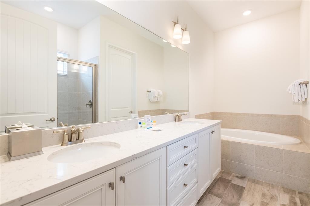 8145 Surf Street Kissimmee, FL 34747 - Photo 13 of 28 a bathroom with a double vanity sink mirror and bathtub