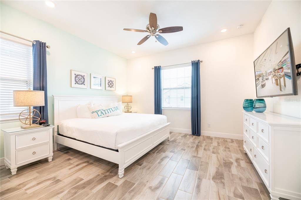 8145 Surf Street Kissimmee, FL 34747 - Photo 17 of 28 a bedroom with a large bed and a chandelier