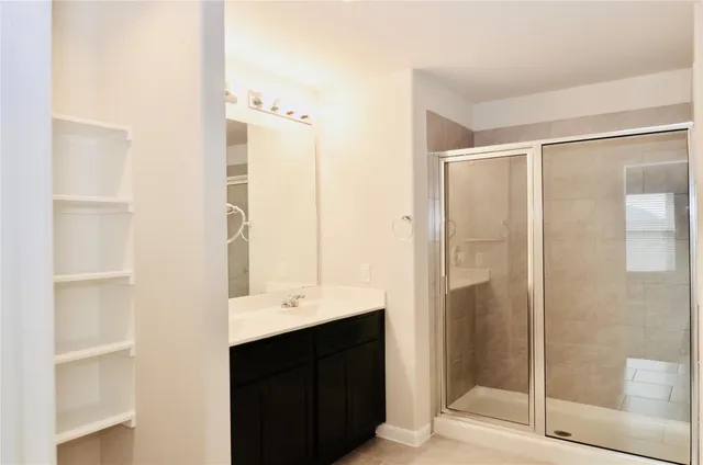 a bathroom with a double vanity sink mirror and shower